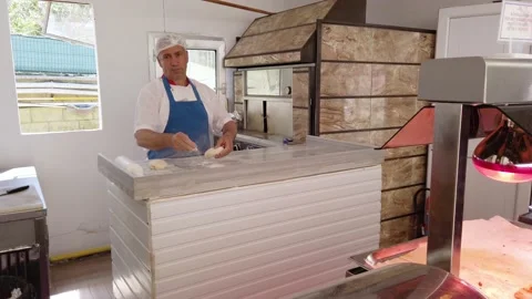 Pizza maker kneads and cuts the dough on a marble table. Stock Footage 201920246