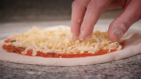Pizza maker puts grated cheese to bake pizza for client Stock Footage 132126121