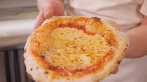 Pizza maker shows baked dish with cheese and tells recipe Stock Footage 132735153