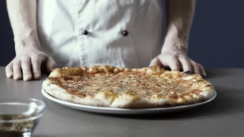 Pizza maker slicing a delicious freshly cooked pizza Stock Footage 127414308