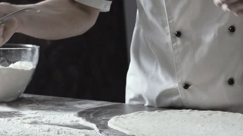 Pizza maker spreading tomato sauce on the dough Stock Footage 127414717