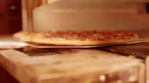 The pizza maker takes out the finished pizza from the oven Stock Footage 158403696