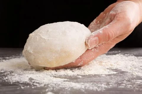 Pizza making. Dough in female hand. Stock Photos