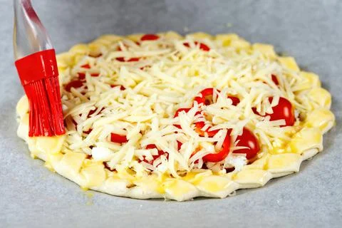 Pizza making process. Top view of pizza dough base with a braided pie crust Stock Photos
