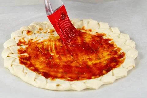 Pizza making process. Top view of pizza dough base with a braided pie crust Foto stock