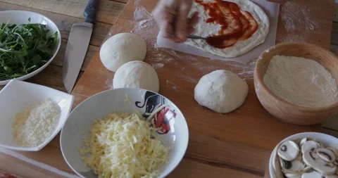 Pizza making, spreading tomato passata over dough Stock Footage 105231273