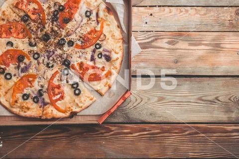 Pizza Margarita in a box on a wooden table. Delivery of pizza concept. Easy Stock Photos
