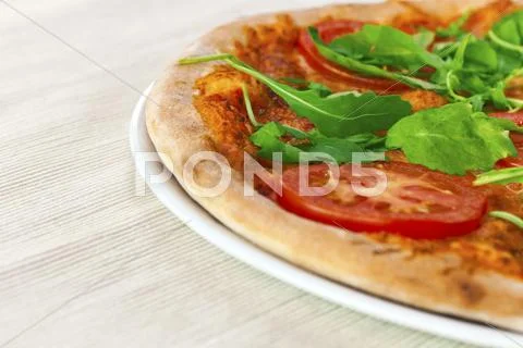 Pizza margharita with arugula and slices of tomato Stock Photos