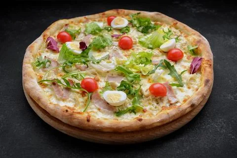 Pizza with meat. tomatoes, quail eggs, and herbs. deluxe pizza Stock Photos