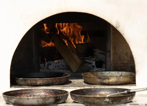 A pizza oven with a fire burning inside Stock Photos