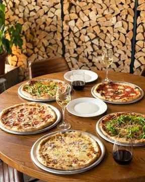 Pizza party. Assorted five different pizzas on wooden restaurant table with Stock Photos