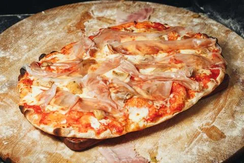 Pizza Perched on Rustic Board Stock Photos