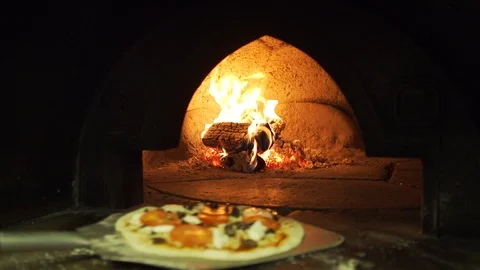 Pizza placed into burning pizza oven in professional restaurant kitchen Stock Footage 101647066