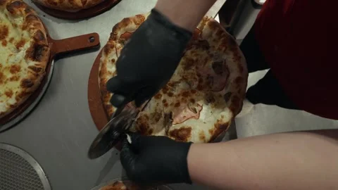 Pizza preparation process showing a gloved hand lifting a freshly baked pizza, Stock Footage 332736760