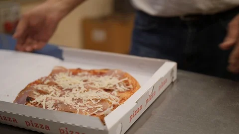 Pizza is ready and man closes a cardboard takeaway box and gives it to buyer Stock Footage 99003501