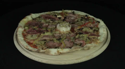 Pizza is rotated on a black background Stock Footage 35347924