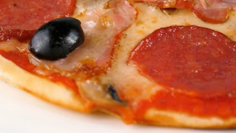 Pizza with salami, sliced ham, bacon, mushrooms and black olives Stock Footage 87689736
