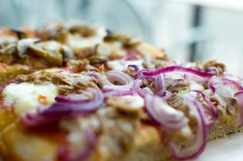 Pizza by the slice (square pizza) - focus on onion Stock Photos