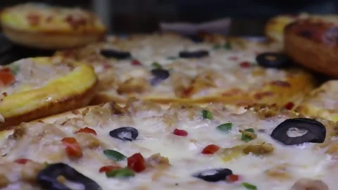 Pizza slices and mini pizzas in warm close up showing melted cheese Stock Footage 338164371