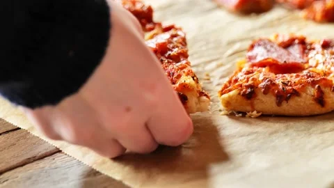 Pizza slicing. hand takes a slice of pizza from baking paper. Stock Footage 239891334