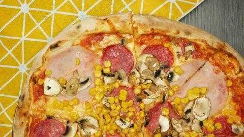 Pizza is spinning on a dark table with a yellow napkin Stock Footage 195952999