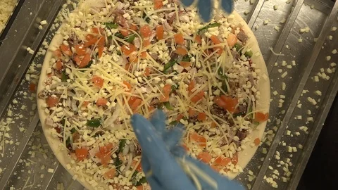 Pizza is sprinkled with cheese. Video stock 126911626