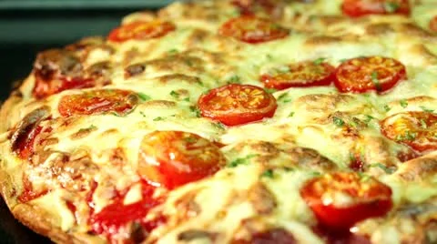 A pizza topped with mozzarella and cherry tomatoes, baking in the oven Stock Footage 24673327