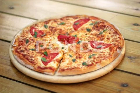 Pizza on a wooden plate Stock Photos