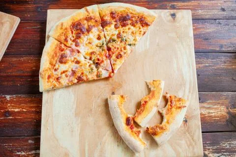 Pizza on a wooden tray. Dry crusts of the edge of the pizza Stock Photos
