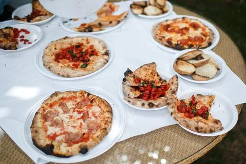 Pizzas on the table in plastic plates Stock Photos