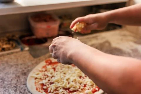 Pizzeria chef unrecognizable hands preparing a fresh pizza. professional kitchen Stock Photos