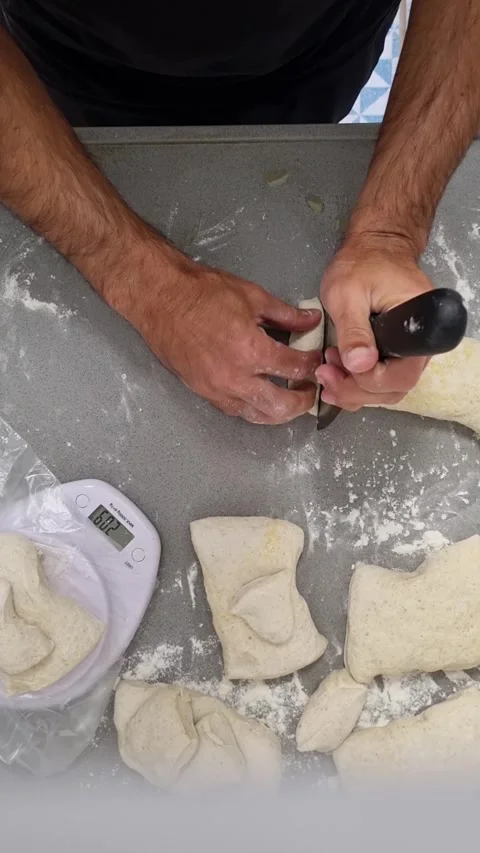 Pizzeria dough portioning with bench scraper and scale ensuring uniform 250 gram Stock Footage 327397441