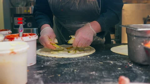 Pizzeria, Professional Chef Cooking Quickly Adds Toppings to Raw Dough in St Stock Footage 234430013