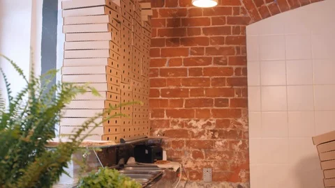 Pizzeria worker carries empty pizza boxes and puts on stack Video stock 127214996