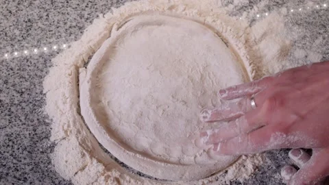 Pizzeria worker rolls dough in flour forming pizza on table Stock Footage 133359664
