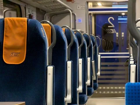 PKP Intercity train interior with blue passenger seats and orange headrests Foto stock