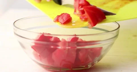 Place the chopped Red Tomato from the cutting board into a bowl. Close-up. Stock Footage 250176906