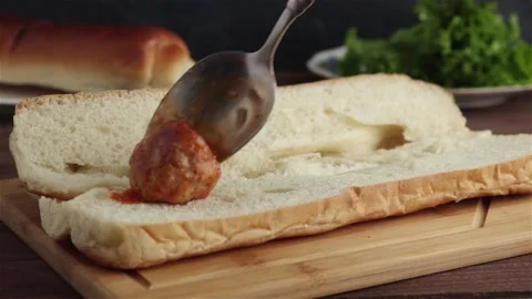 Place hot meatballs on bread making sandwcih close up Stock-Footage 112662078