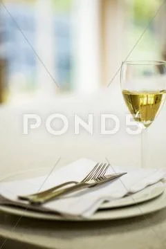 Place-Setting And Glass Of White Wine