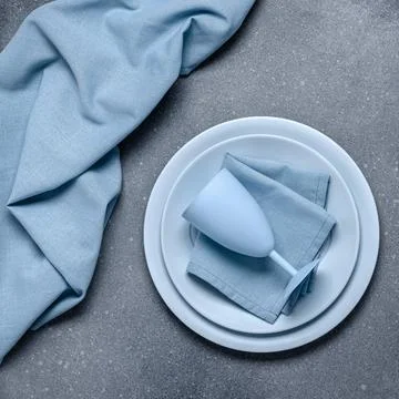 Place setting with blue dishes. Empty plates and napkin on gray concrete ba.. Stock Photos