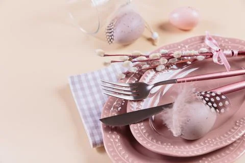 Place table setting and festive decor with easter eggs on beige background Stock Photos
