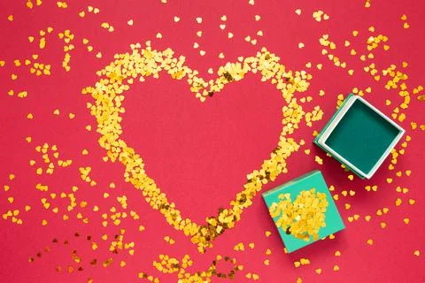 Place for text made of gold sparkles in the shape of a heart with open gift b Stock Photos