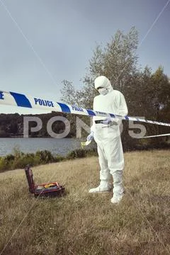 Places of crime - specialist behind barrier tape on place of crime Stock Photos