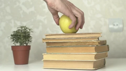 Placing Apple on Books as Sign of Knowledge Stock Footage 154659245