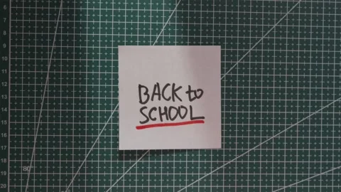 Placing Back to School paper note centrally on green mat Stock Footage 341269391