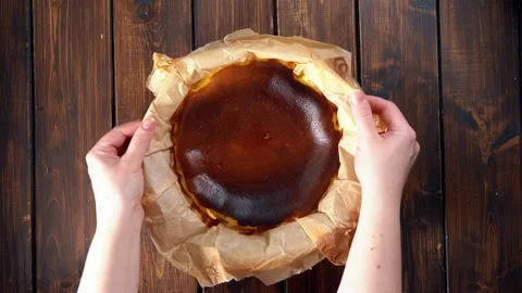 Placing baked basque burnt cheesecake on a rustic table by woman's hands Stock Footage 146345277