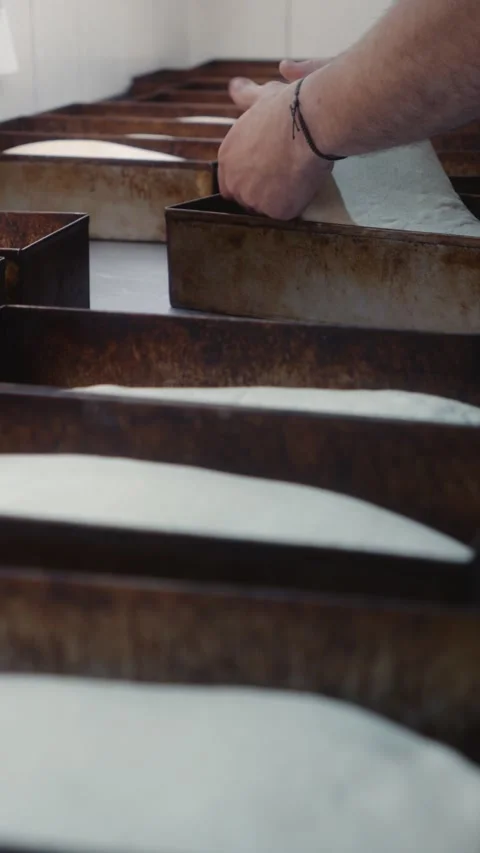 Placing bread dough into metal baking molds Stock Footage 344313163