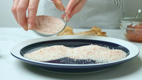 Placing a bunch of salt into a serving plate in 4K. Stock Footage 142686681