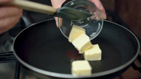 Placing butter cubes in a hot pan and melting them with a spatula. Stock Footage 132822242