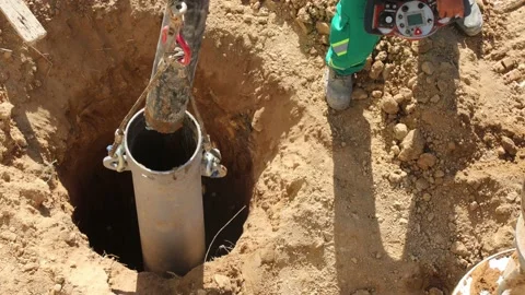 Placing cement pumping hose into deep foundation tube Stock Footage 224678088